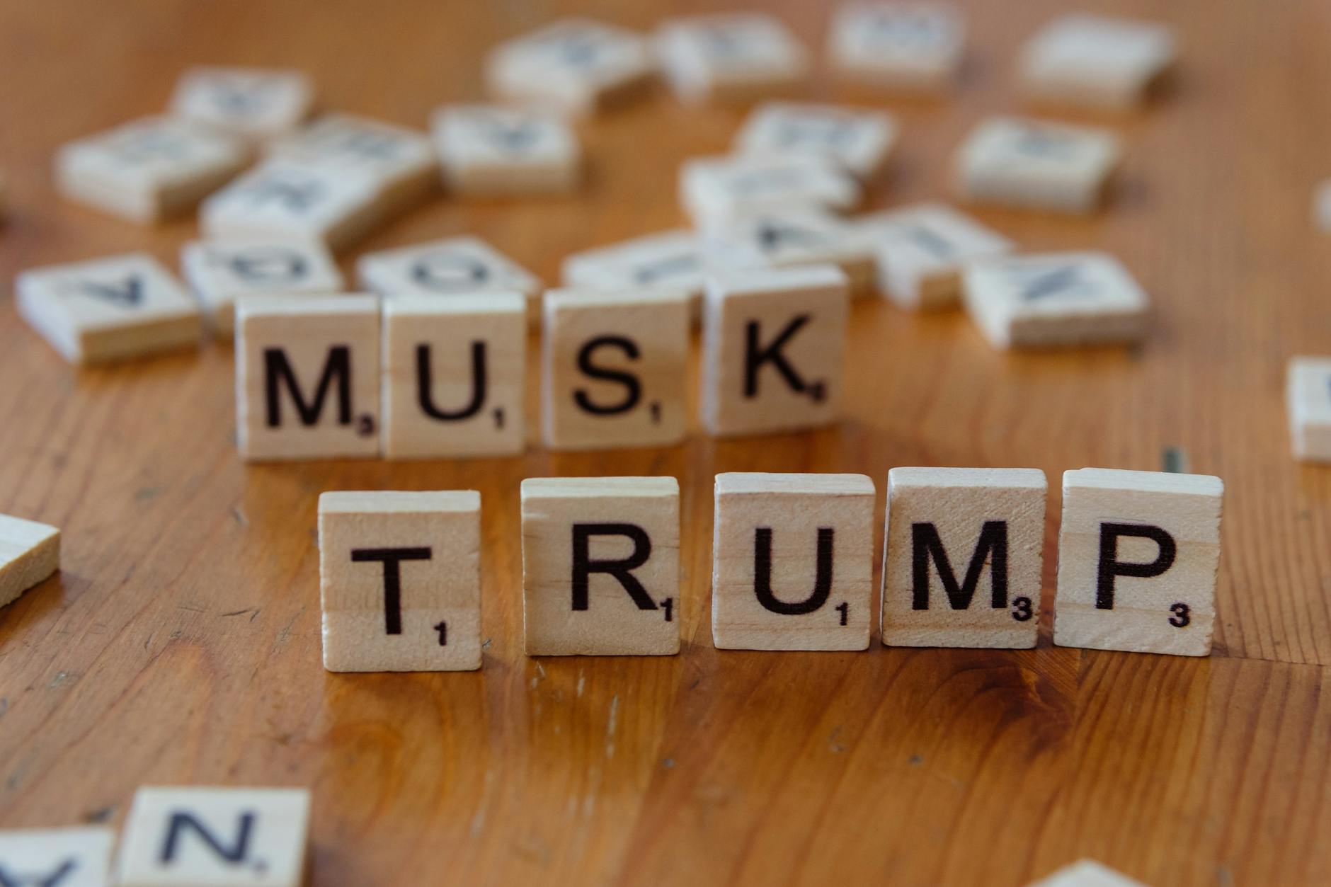 Scrabble game tiles notably spell out 'Musk' and 'Trump' on a wooden table, sparking cultural conversation.